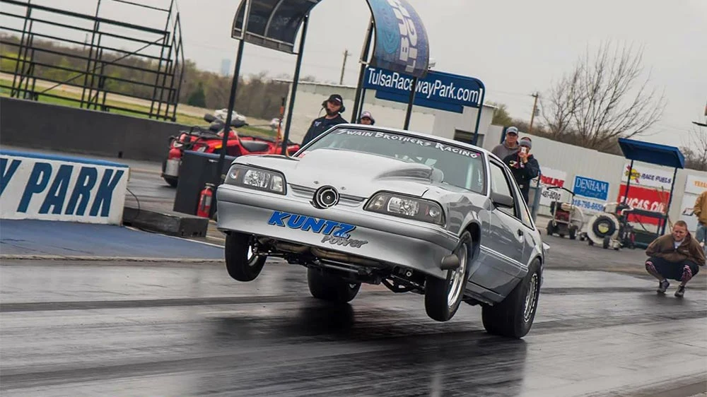 Kuntz-powered silver Mustang launching with its front wheels off the track